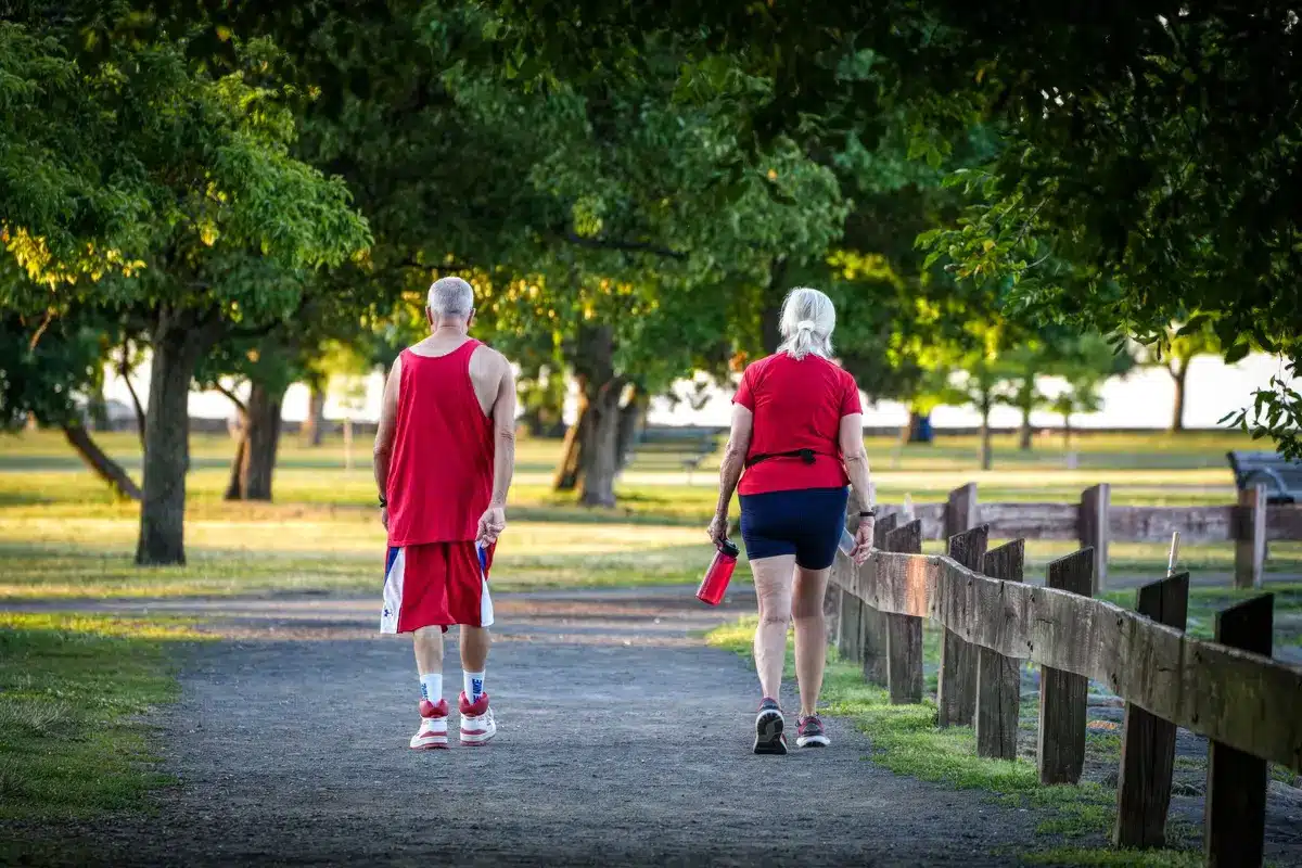 Femme marchant dans un parc, souriante, avec une bonne posture