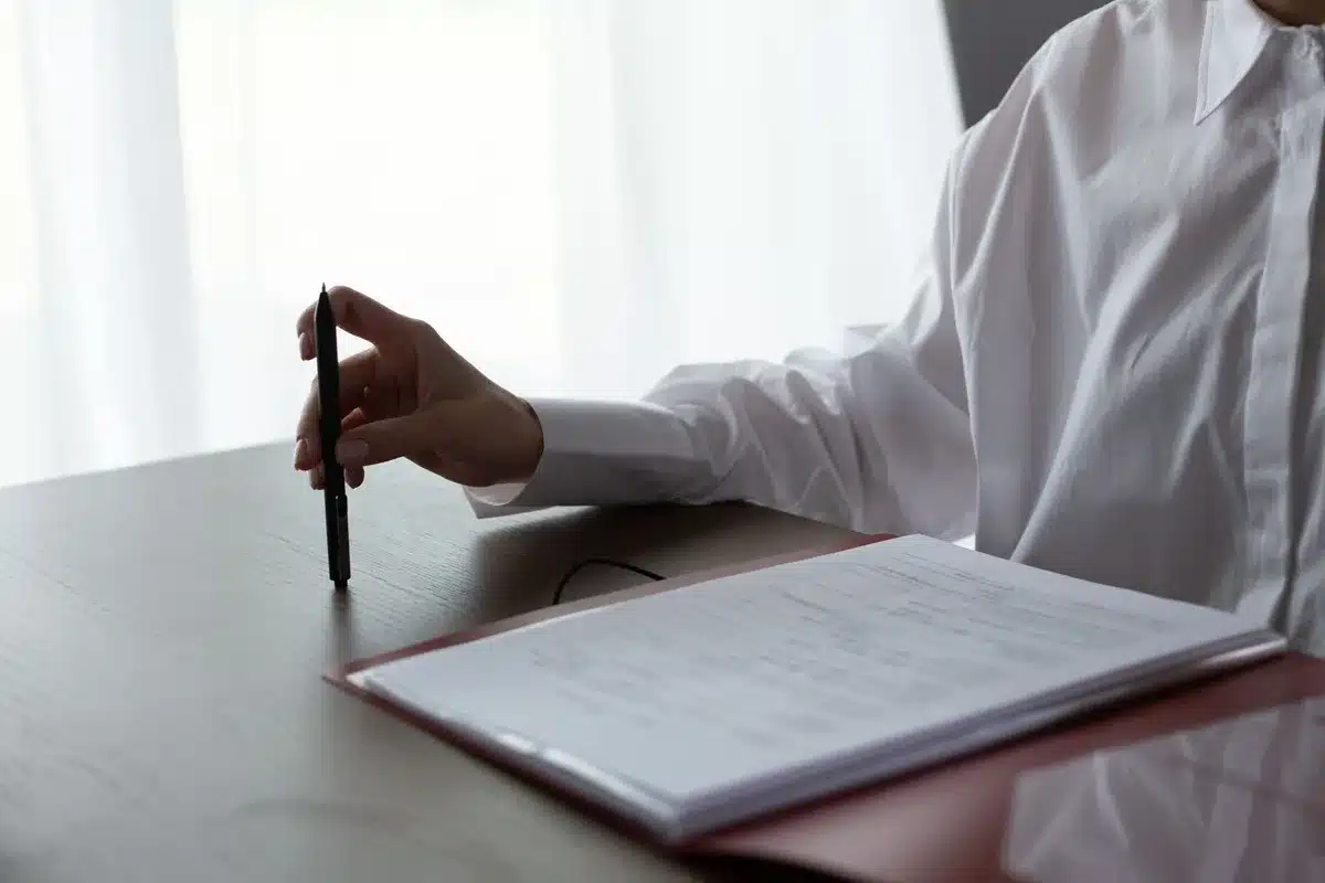 Femme examinant attentivement des documents médicaux et factures détaillées