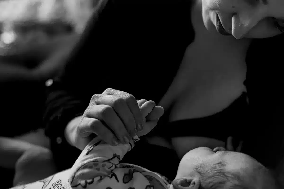 Une mère tenant tendrement son nourrisson, offrant sécurité et confort dans les premiers mois.
