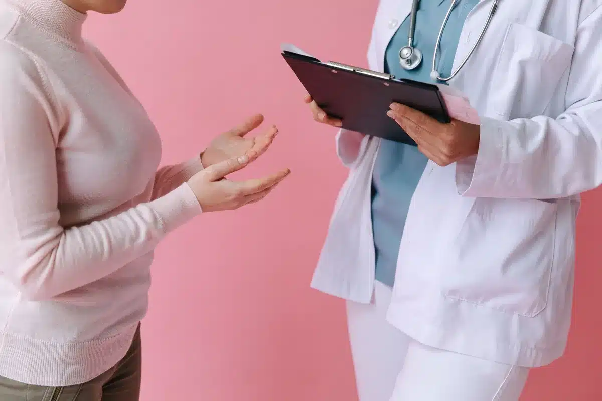 Mains d'un professionnel de santé tenant un protocole de diagnostic sur un bureau médical
