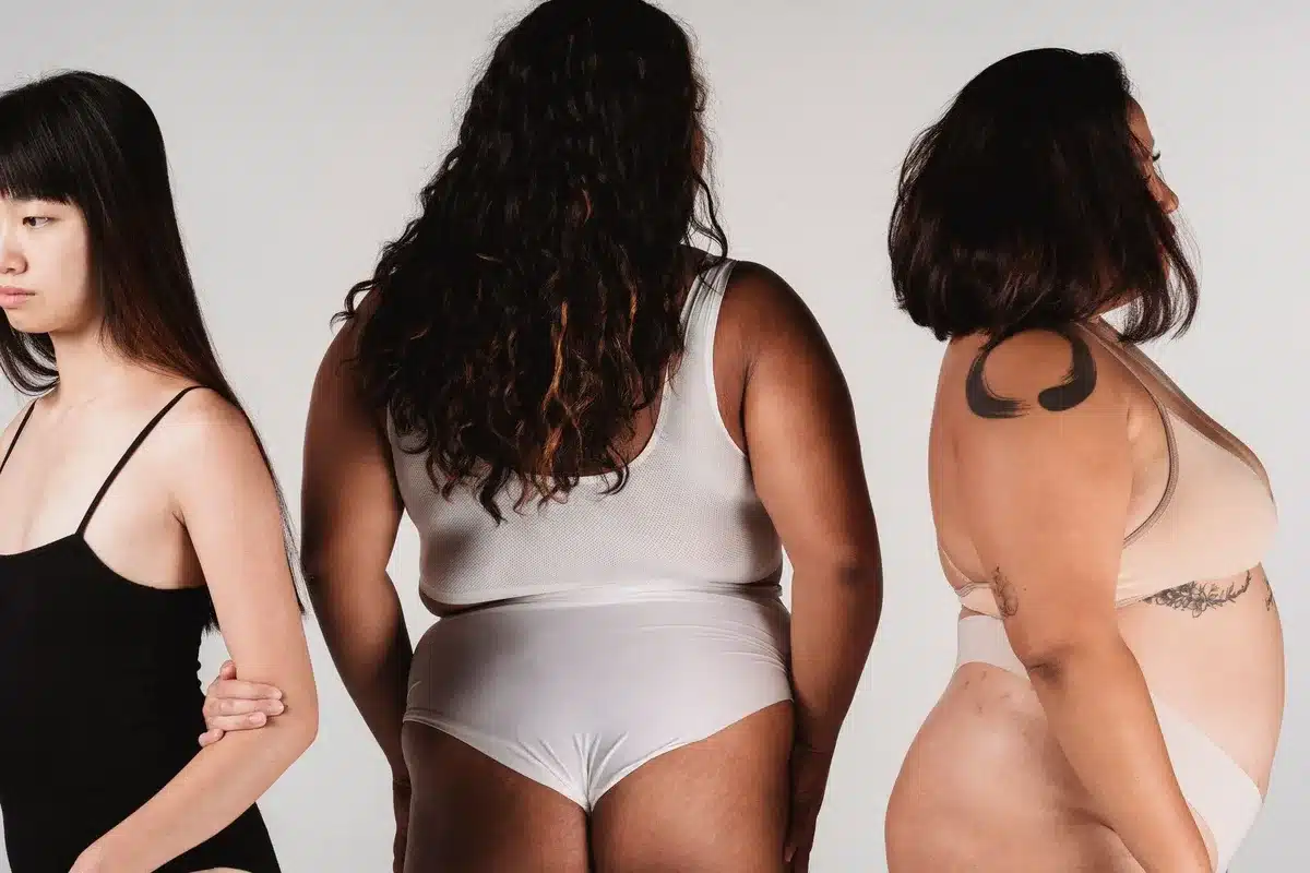 Mannequins de silhouettes variées sur un podium de mode, illustrant la diversité corporelle