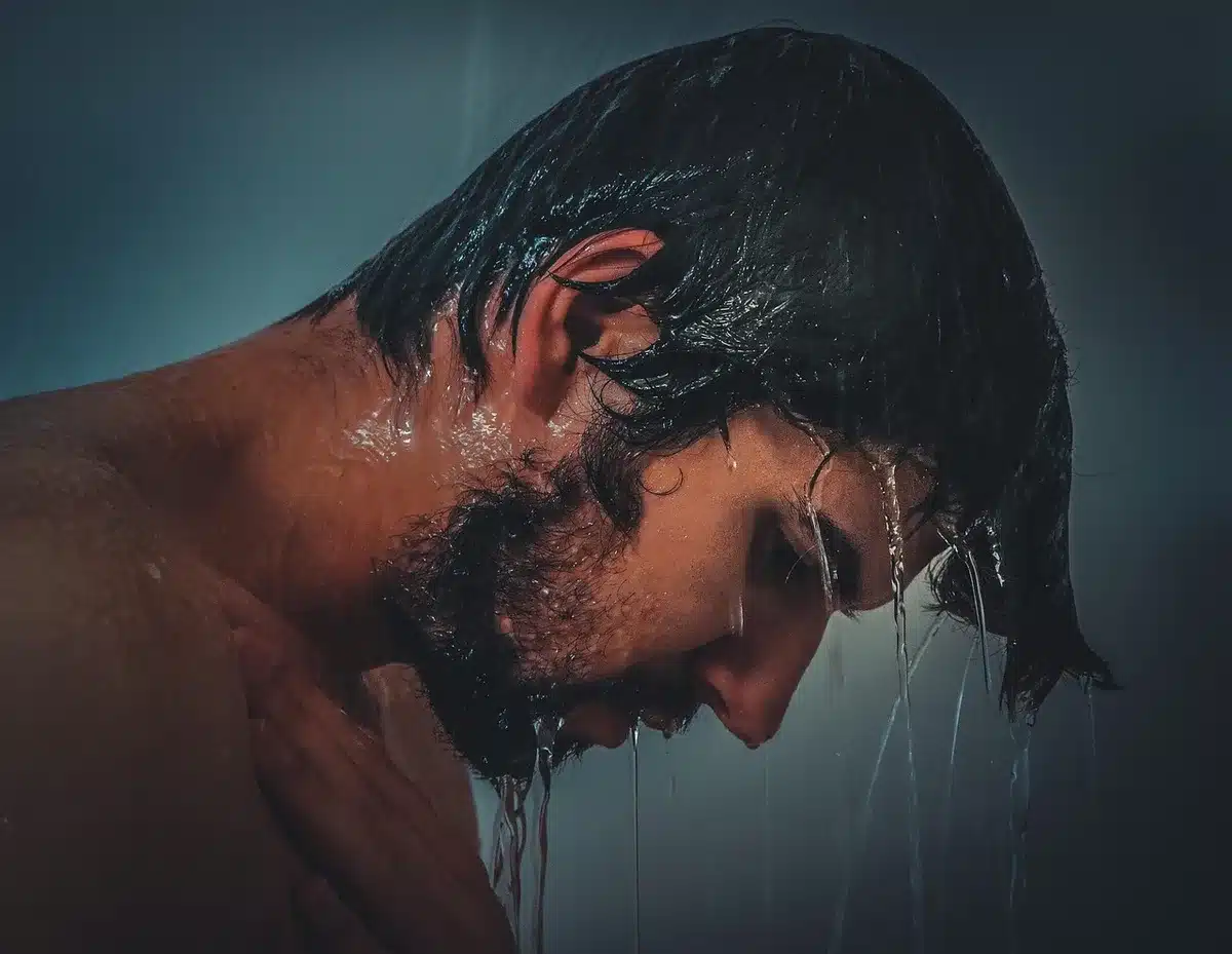 Personne prenant une douche du soir avec un gel douche parfumé à la noix de coco