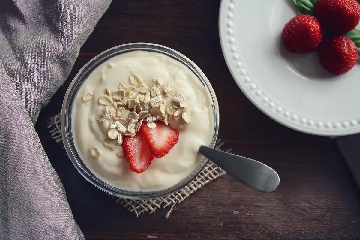 Petit déjeuner équilibré avec une viennoiserie, yaourt et fruits frais
