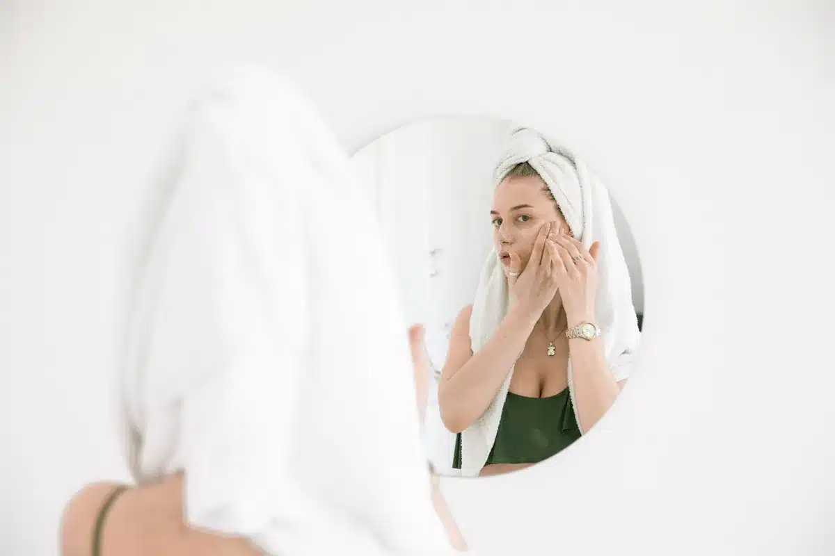 Produits de soin et serviette sur une vasque baignée de lumière naturelle