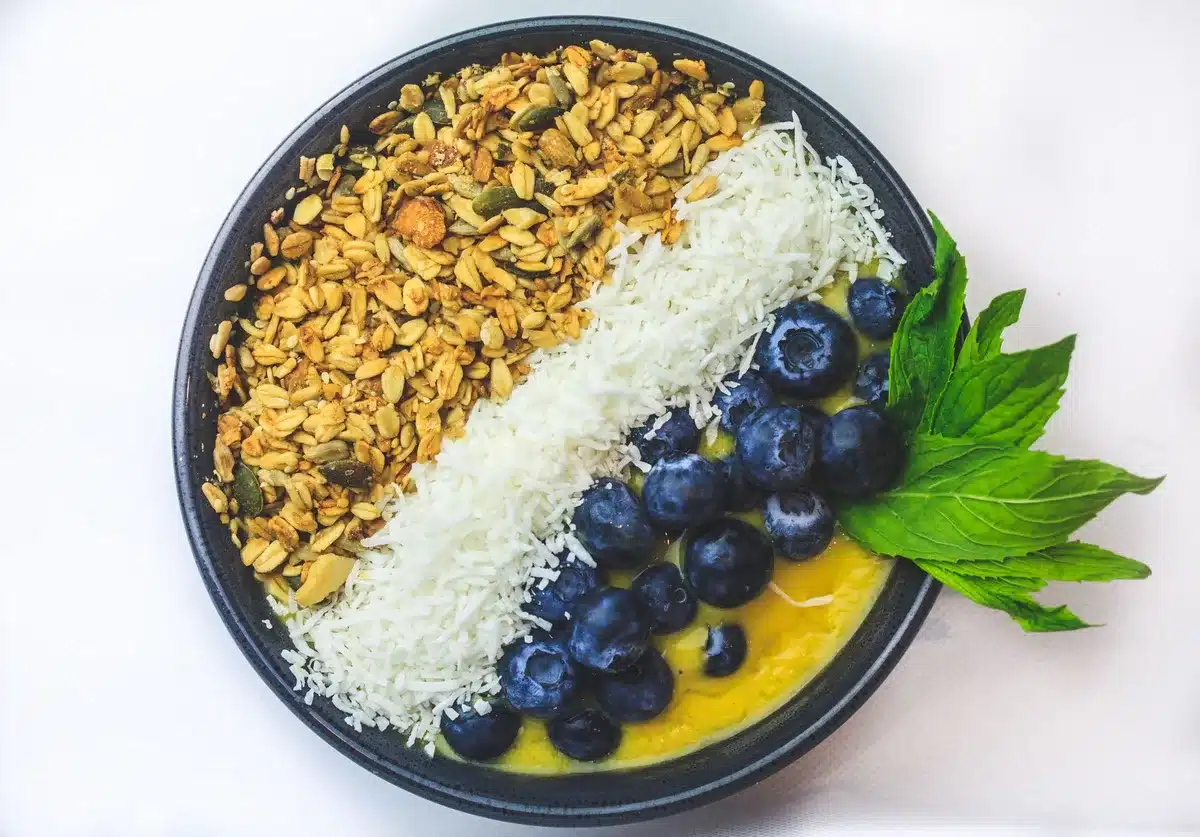 Bol de pudding de chia avec fruits rouges sur une table près d'une fenêtre en journée